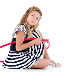 The little girl turns the hoop.