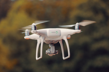 drone quad copter with high resolution digital camera against natural bokeh background - obrazy, fototapety, plakaty