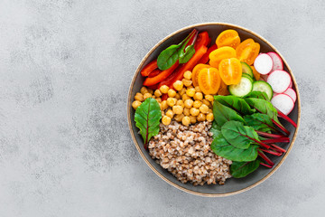 Vegetarian Buddha bowl with boiled buckwheat, chickpea and vegetables, top view