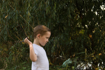 Cheerful and naughty boy playing in nature