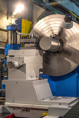 The big industrial CNC lathe machine cutting the steel rod