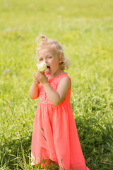 happy little girl in a bright dress eating ice cream 