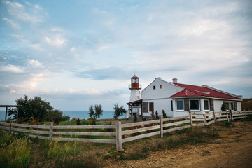 Fototapeta na wymiar Old white lighthouse on the sea coast