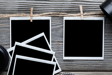 Photo frames and lenses on wooden board