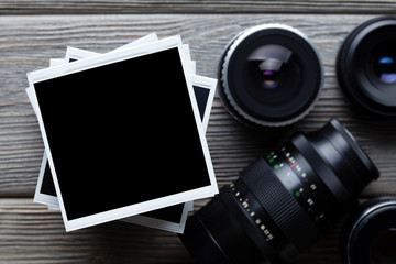 Old black lenses and classic photo frames on wooden background