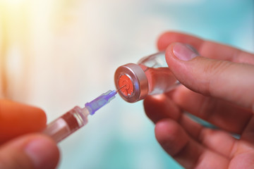 Closeup of vaccine bottle with syringe and needle for immunization on vintage medical background, medicine and drug concept