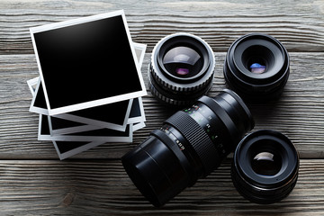Lenses and photo frames on wooden table