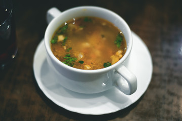 Noodles soup in a white bowl on a table.
