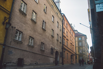Ancient narrow Warsaw street with old architecture and winter background