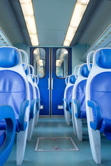Empty interior of the train for long and short distance in Europe train carriage with blue seats. low cost travel concept