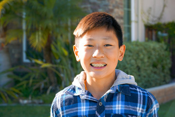 Portrait of young Asian boy with tooth braces. Young teen boy smiling and showing his orthodontic braces on his teeth.