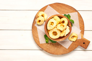 Dried apple on wooden chopping board. 