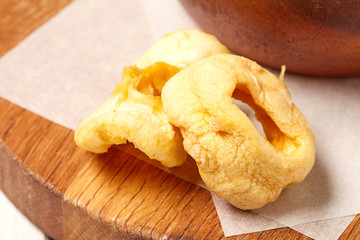 Dried apple on wooden chopping board. 