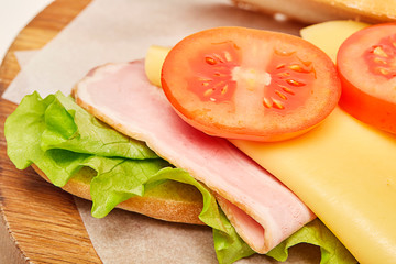 Sandwich baguette on wooden chopping board. 
