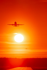 Civil airplane taking off in susnset colors