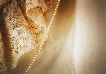 Closeup detail of vintage satin and lace wedding dress with a strand of tiny pearls. Heavy vintage...