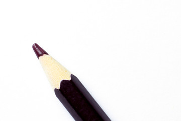Brown Pencil lying on white paper. Macro shot of a pencil close up on white.