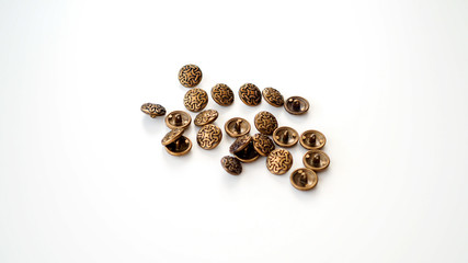 Metalowe guziki. Złote, srebrne, ciemne guziki leżące na białym tle