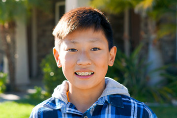 Portrait of young Asian boy with tooth braces. Young teen boy smiling and showing his orthodontic braces on his teeth.