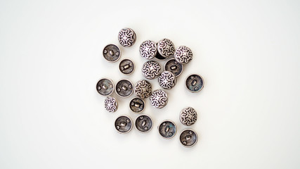 Obraz premium Metalowe guziki. Złote, srebrne, ciemne guziki leżące na białym tle