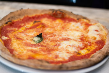 Neapolitan Pizza Margherita On A Tray On A Table In A Restaurant in Naples, Italy.