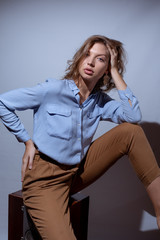 Stylish look of a sexy woman in a blue shirt. Street style studio photography. Model test