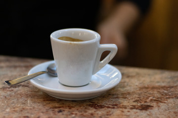 White Espresso Coffee Cup On A Saucer With A Spoon On Marble Counter.