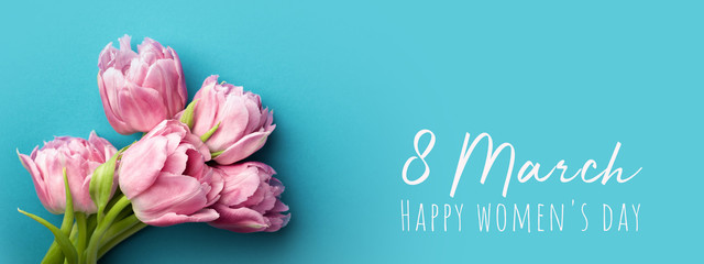 Pink tulips on turquoise background with copy space. Happy women's day greeting card.