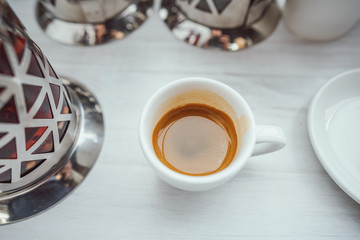 Cup of cappuccino on the white wooden table.