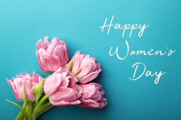 Pink tulips on turquoise background with copy space. Happy women's day greeting card.
