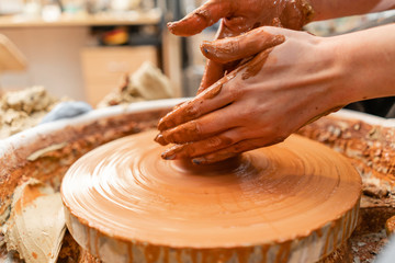 Craftsman hands making pottery bowl. Woman working on potter wheel . Family business shop sculpts pot from clay view top.