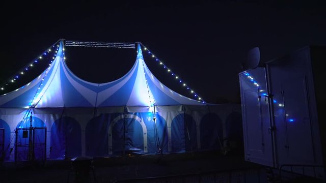 Exterior of a circus tent illuminated at night