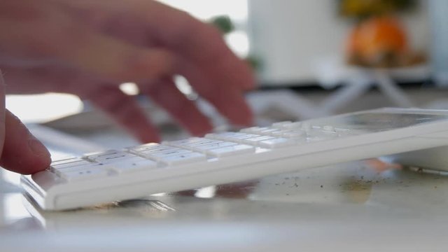 Man at Home Read and Counting Payments from Shopping List Using Adding Machine 
