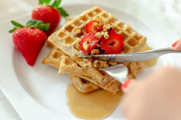 Desayuno saludable - waffles de harina del negrito, servidos con nueces, fresas y miel