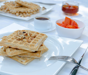 Desayuno saludable - waffles de harina del negrito, servidos con nueces, papaya, miel y café