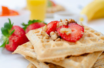 Desayuno saludable - waffles de harina del negrito, servidos con nueces, fresas y jugo fresco