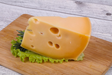 Maasdam cheese  in the board served salad leaves