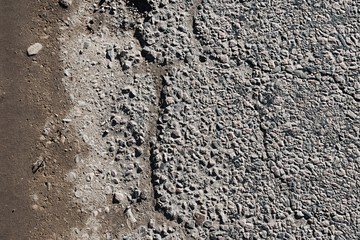 Road with a lot of cracked asphalt parts together next to ground