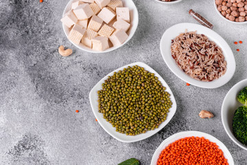 Superfoods on a gray background with copy space. Nuts, beans, greens and seeds. Healthy vegan food