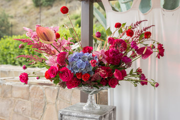Flower arrangement of bright colors in a glass vase. Wedding floristry