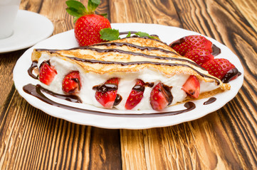 Crepes with Banana and strawberries on a wooden background, pancakes.