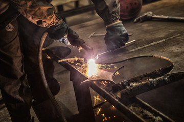 Cropped shot of a professional metalworker cutting steel sheet with a manual plasma cutting...