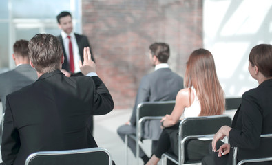 staff member raises a hand at a conference to answer a question