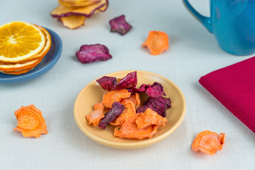 Healthy food organic nutrition. Sliced and dried apple, orange, carrot and beetroot  and cup of tea on textile tablecloth.