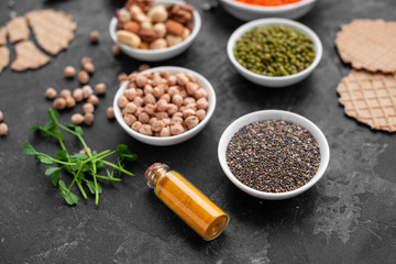 Superfoods on a gray background with copy space. Nuts, beans, greens and seeds. Healthy vegan food