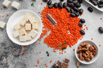 Superfoods on a gray background with copy space. Nuts, beans, greens and seeds. Healthy vegan food