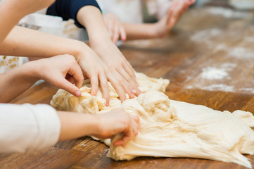 Young children make dough products. Hands closeup