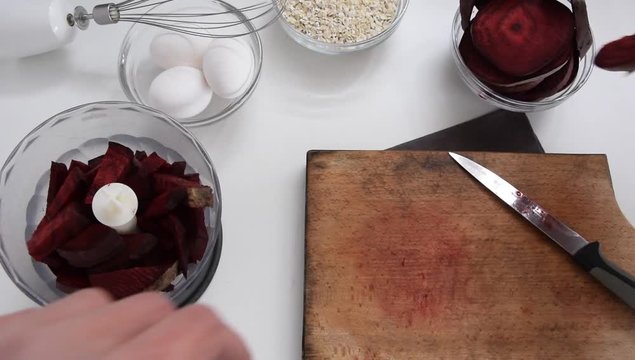 Top view of woman hands cooking healthy dessert with red beet roots, oats and fresh eggs