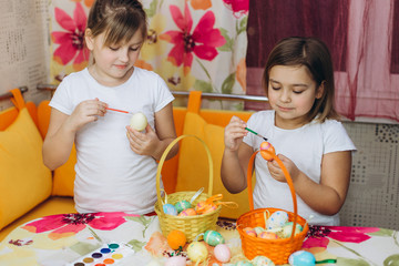 Two cute pretty preschool girl prepare easter eggs, drawing eggs together. Friendship, childhood, easter concept