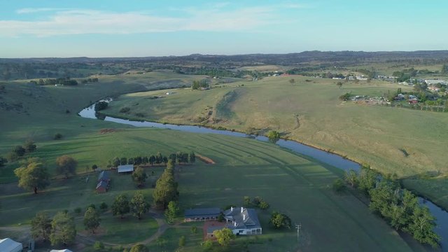 Horizontal pan across scenic countryside and river at sunset in Australia